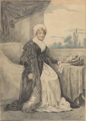 Frau, die an einem Tisch sitzt und einen Brief hält