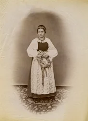 Junge Frau im Hochzeitskleid und mit einem mit Band umwickelten Brotkranz, Parre, Lombardei, Italien, Fotografie von Premiata Fotografia Taramelli, Bergamo
