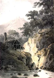 Felsige Landschaft in Cornwall mit Ruinen einer Burg in der Ferne