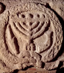 Judentum: Architekturelement aus Basalt einer Synagoge, verziert mit einem siebenarmigen Leuchter (Menora), Palme und Trompete
