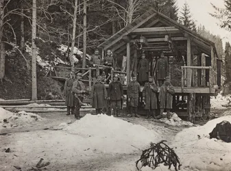 Album "Meine Weltkriegs-Erinnerungen Südwestfront (Kärnten, Italien, Südtirol) 31.03.1915-12.11.1918 - Josef Zohles Wien": Soldaten vor einem Kabel (s/w Foto)