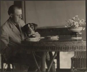 Mann und Hund am Tisch sitzend