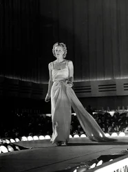 Modell auf dem Laufsteg in einem Abendkleid mit Strass-Trägern; kreiert vom Modehaus "Fumach".
