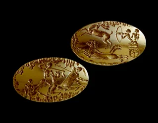 Mykenische Kunst: zwei Goldsiegel mit der Darstellung einer Jagdszene auf einem Streitwagen und eines Kriegers, der drei Gegnern gegenübersteht. 1550-1100 v. Chr. aus Grab IV von Mykene. Archäologisches Nationalmuseum Athen (Inv. 240 und 241)