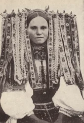 Tschechische Frau mit einem Kopfschmuck aus Bändern, wobei jedes Band einen abgelehnten Verehrer symbolisiert