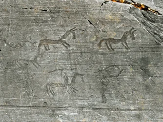 Vorgeschichte, Zivilisation der Camunni, Felskunst: ein gravierter Felsen mit einer Jagdszene, ein Jäger schwingt einen Speer. Zeit zwischen Jungsteinzeit und Bronzezeit. Capo di Ponte, Nationalpark der Felsritzungen von Naquane, Valcamonica, Val