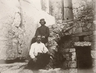 Zwei Männer sitzen neben dem Türsturz von Barclays Tor in der Westmauer des Tempelbergs, Jerusalem, 1866
