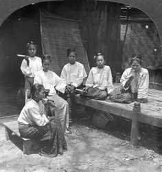 Burmesische Frauen rauchen vor ihrem Haus, Mandalay, Burma, 1908