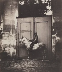 Schwarzer Reiter vor einem Hauseingang, um 1855.