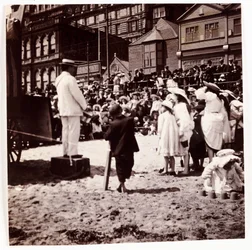 Menschenmenge beobachtet einen Strandunterhalter, um 1905
