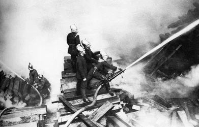 Feuerwehrmänner bekämpfen ein Feuer in einem Holzlager, London