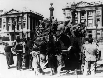 Französische Straßenverkäufer bieten Souvenirs einem Lastwagen voller deutscher Soldaten an, Paris, 27. Juli 1940