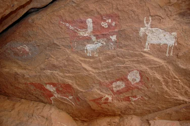 Felskunst, Vorgeschichte: Felsmalerei einer Gruppe von Rindern und Schafen in einem verzierten Schutzraum, im Uweinat-Massiv, Sudan (8000 bis 3000 v. Chr.)