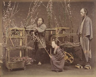 [Zwei japanische Männer und eine japanische Frau posieren mit blühenden Zweigen], 1870er Jahre