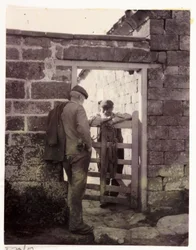 Zwei Männer sprechen über ein Tor, um 1905