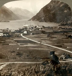 Dächer des Dorfes und sonnige Felder von Odde, N. am engen bergumgebenen Sorfjord, Norwegen