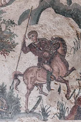 Detail des kleinen Jagdmosaiks. Ein Jäger ist dabei, einen Hasen zu spießen. 3. - 4. Jahrhundert. Römische Villa del Casale, Sizilien. UNESCO-Weltkulturerbe.
