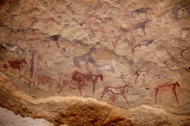 Felskunst, Vorgeschichte: Felsmalerei einer Gruppe von Rindern und polychromen Figuren (Hirten und Bogenschützen) in einem verzierten Schutzraum im Uweinat-Massiv, Sudan. Zeitraum von 8000 bis 3000 v. Chr. Fotografie