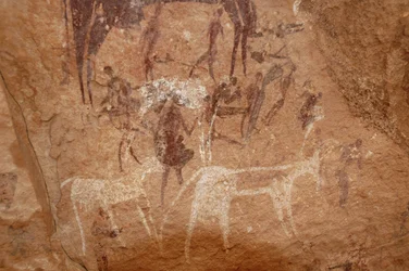 Felskunst, Vorgeschichte: Felsmalerei von Figuren und Kühen in einem verzierten Schutzraum im Uweinat-Massiv, Sudan (Karkur-Talh oder Karkur Talh). Zeitraum von 8000 bis 3000 v. Chr. Fotografie