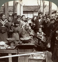 Ein Straßenkünstler mit einem Affen, der die Menge unterhält, Kobe, Japan, 1896