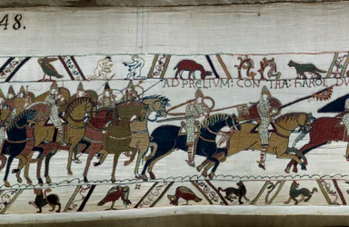Eroberung Englands durch den normannischen Herzog Wilhelm den Eroberer im Jahr 1066: seine Armee marschiert auf die von Harold II. in Hastings zu. Unten links zwei nackte Männer. Detail des Teppichs von Bayeux