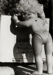 Verlassene Puppe neben einer Kiste