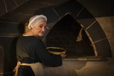 Historische Nachstellung: Magd legt Kuchen in den Ofen der Schlossküche