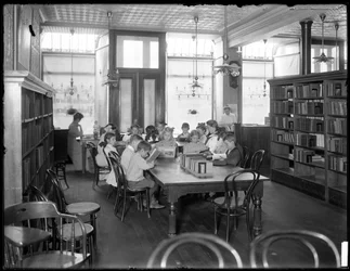 Kinder lesen im Lesesaal einer unbekannten Filiale der Queens Borough Public Library, ca. 1910