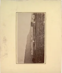 Ansicht eines Palisadenzauns mit mehreren Männern am Eingangstor, 1871